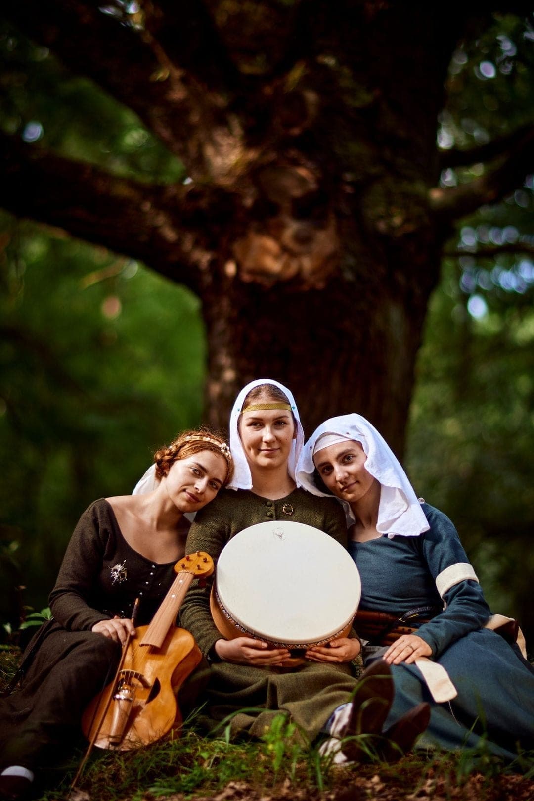 Trzy muzykini z instrumentami w lesie